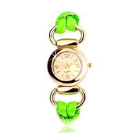 Analogowy zegarek, ogrągły cyferblat złotego koloru, lateksowy zielony pasek