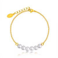Kuleczkowa bransoletka w kolorze perłowym, drobny stalowy łańcuszek w złotym odcieniu